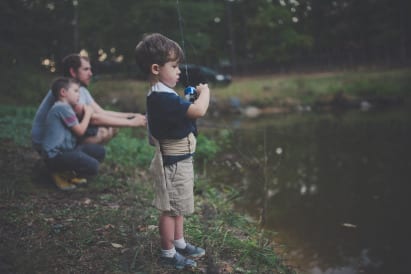 Father fishing with his sons at a pond